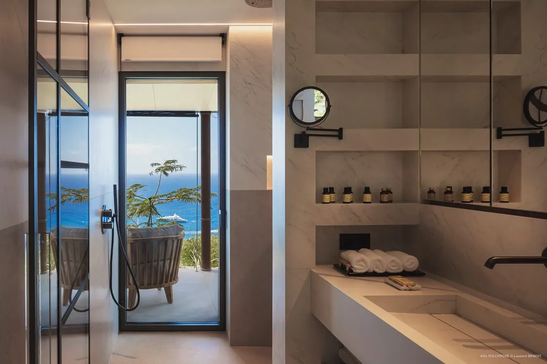 Travertine-clad bathroom with a double basin and natural light