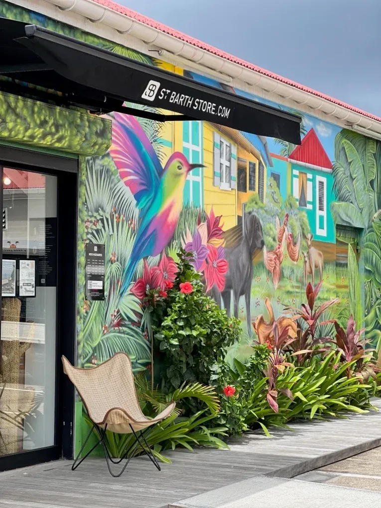 La façade du magasin, aux Galeries du Commerce, à côté d’une fresque murale représentant un colibri et des cases créoles.