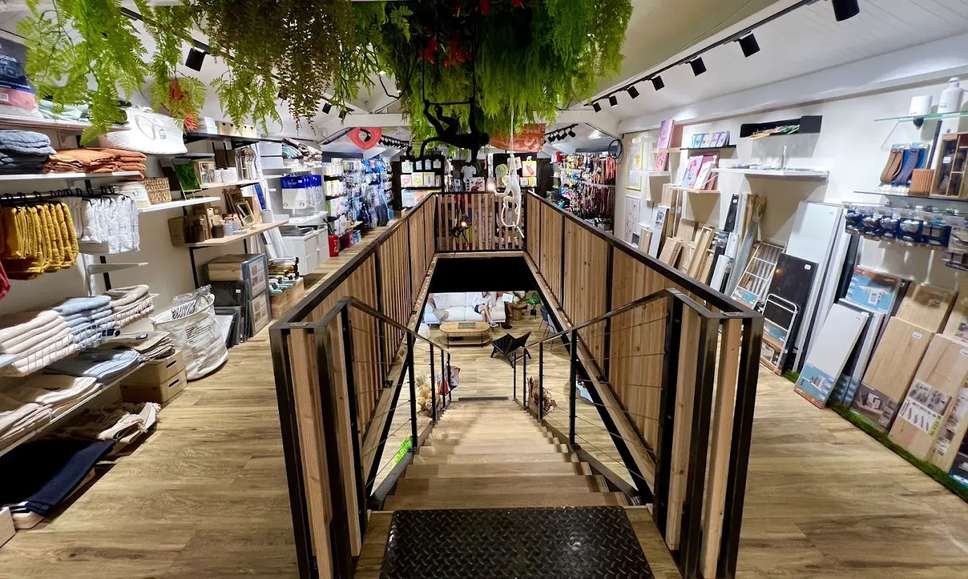 L’entrée du magasin : passerelle en bois, rayonnages d’art de la table et végétation suspendue au plafond.